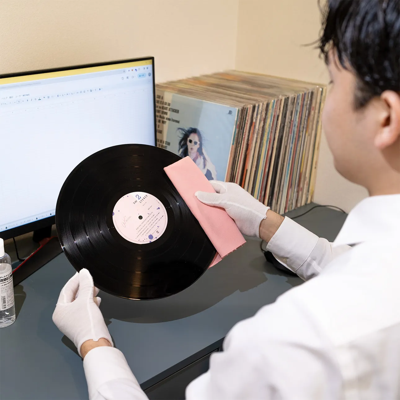 Photograph showing professional curation and inspection of Japanese used vinyl records